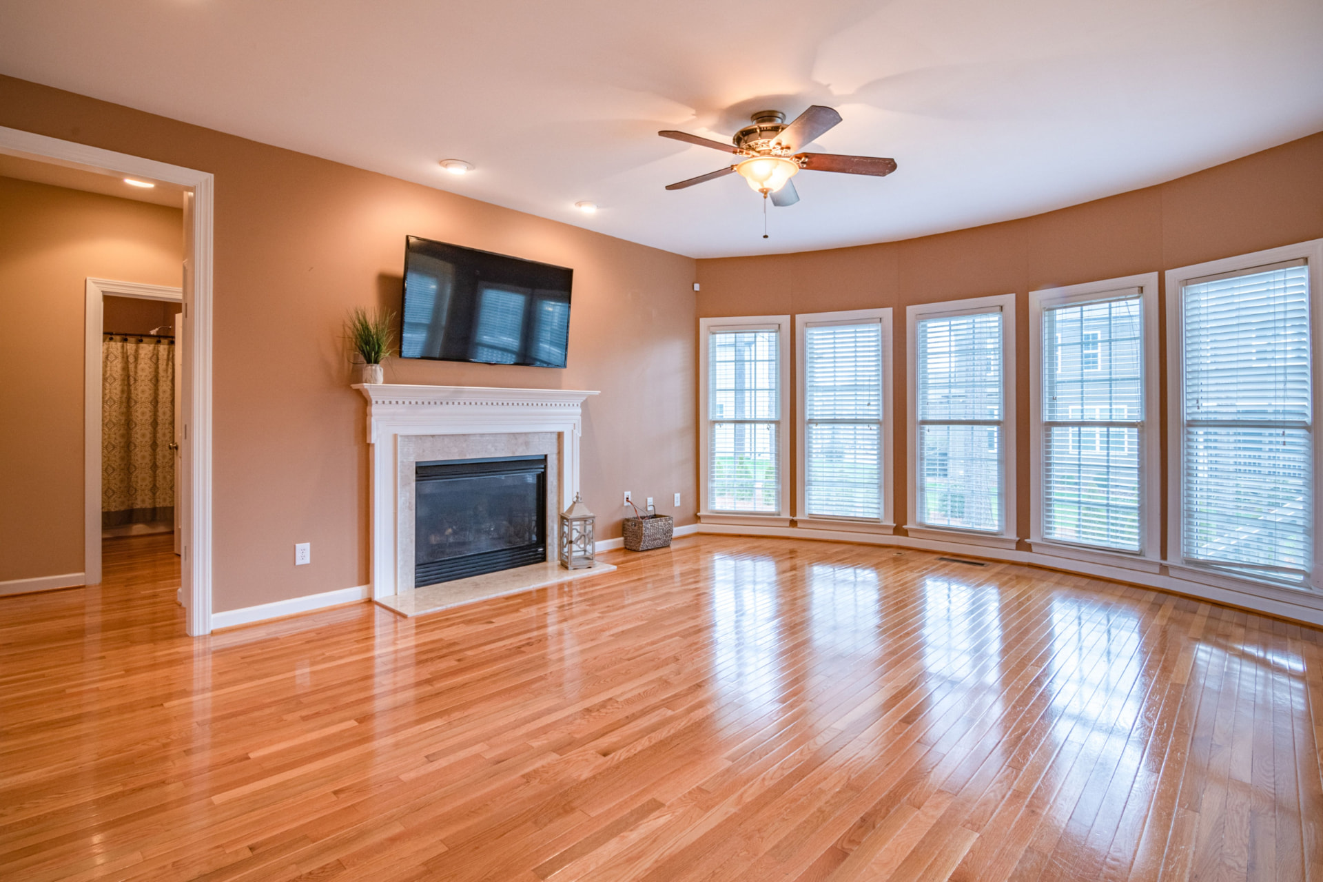 Cleared family room with fireplace and bay windows