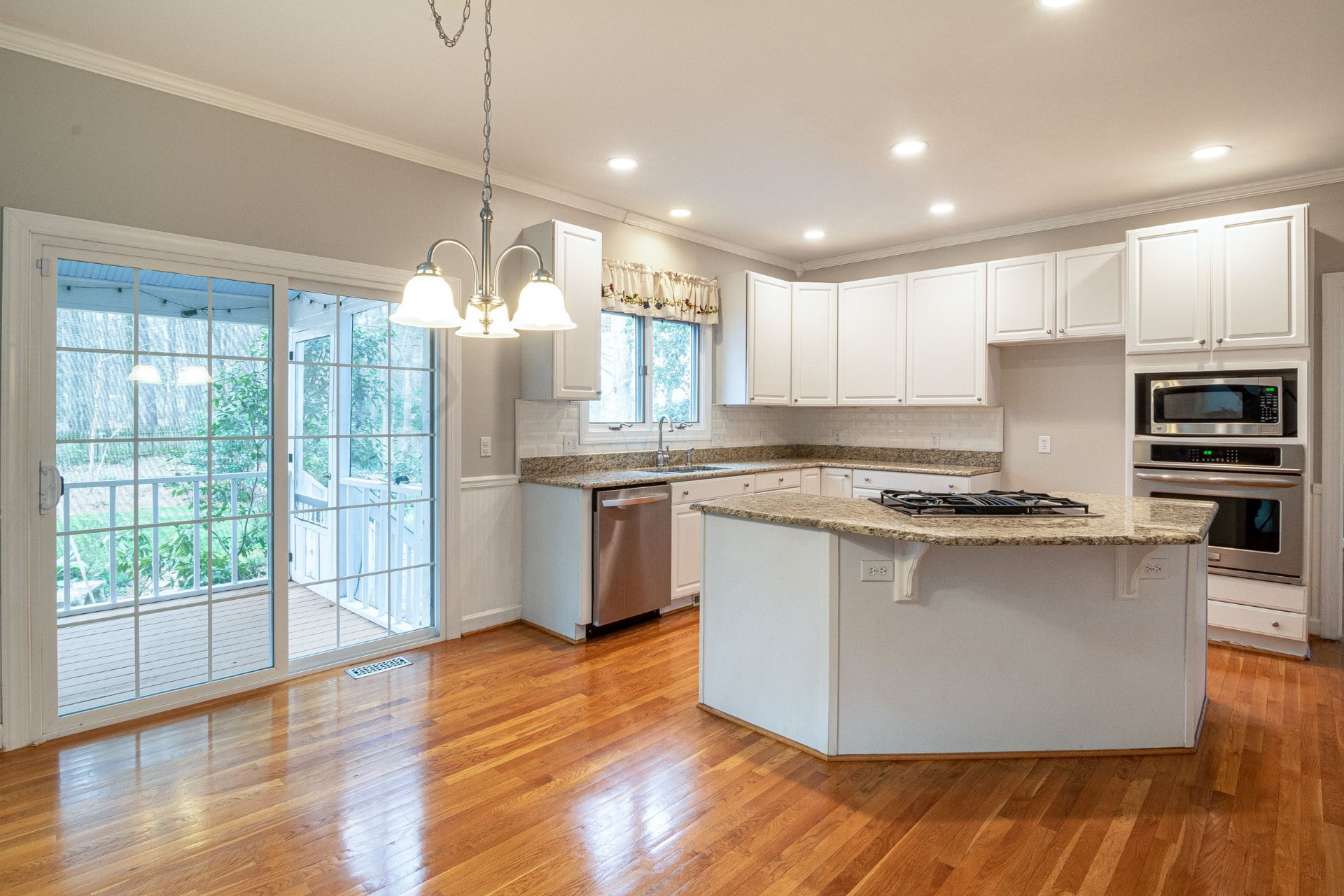 Clean kitchen with white cabinets and granite island
