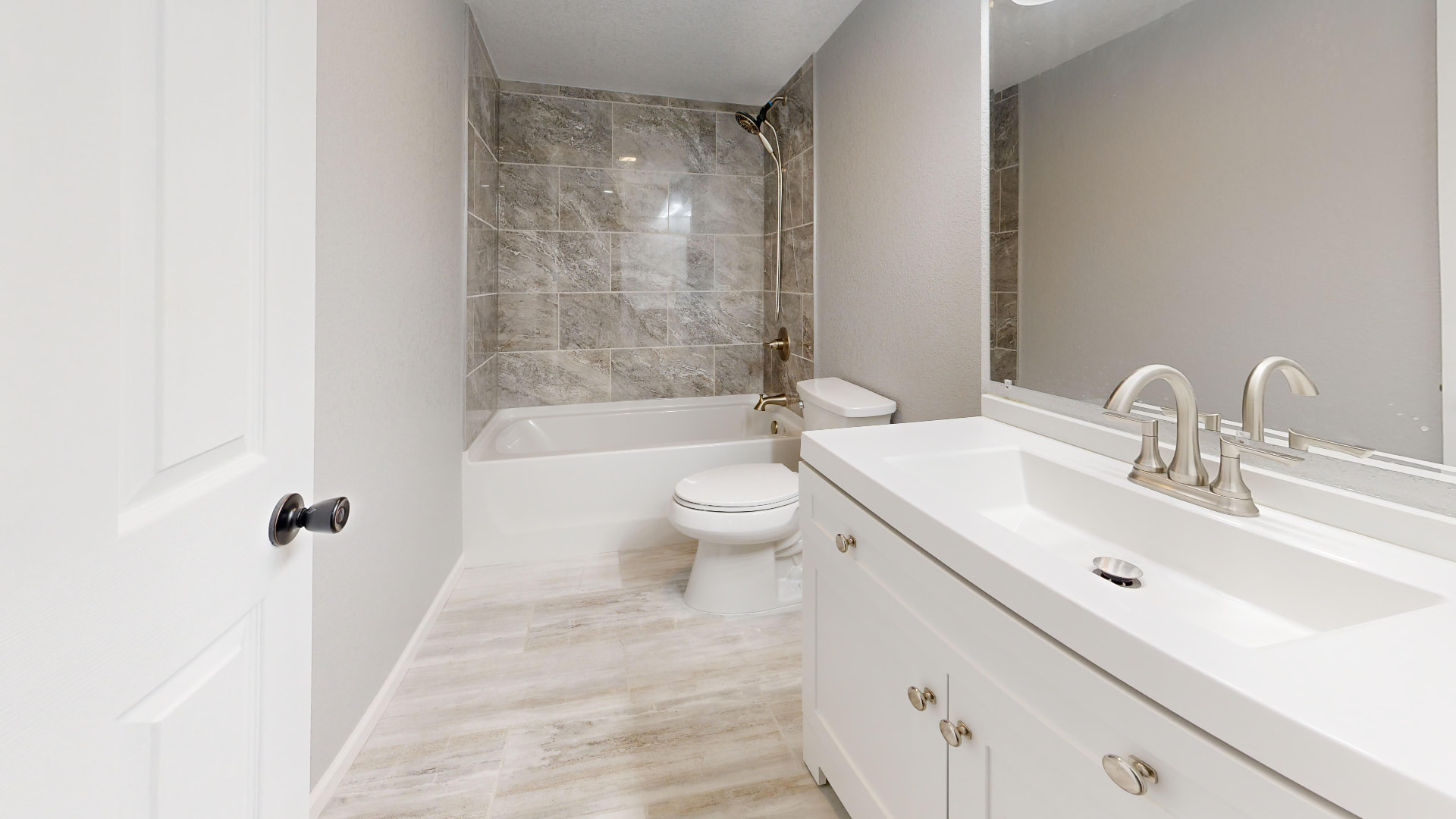 Full bathroom with tub, tile surround and clean vanity